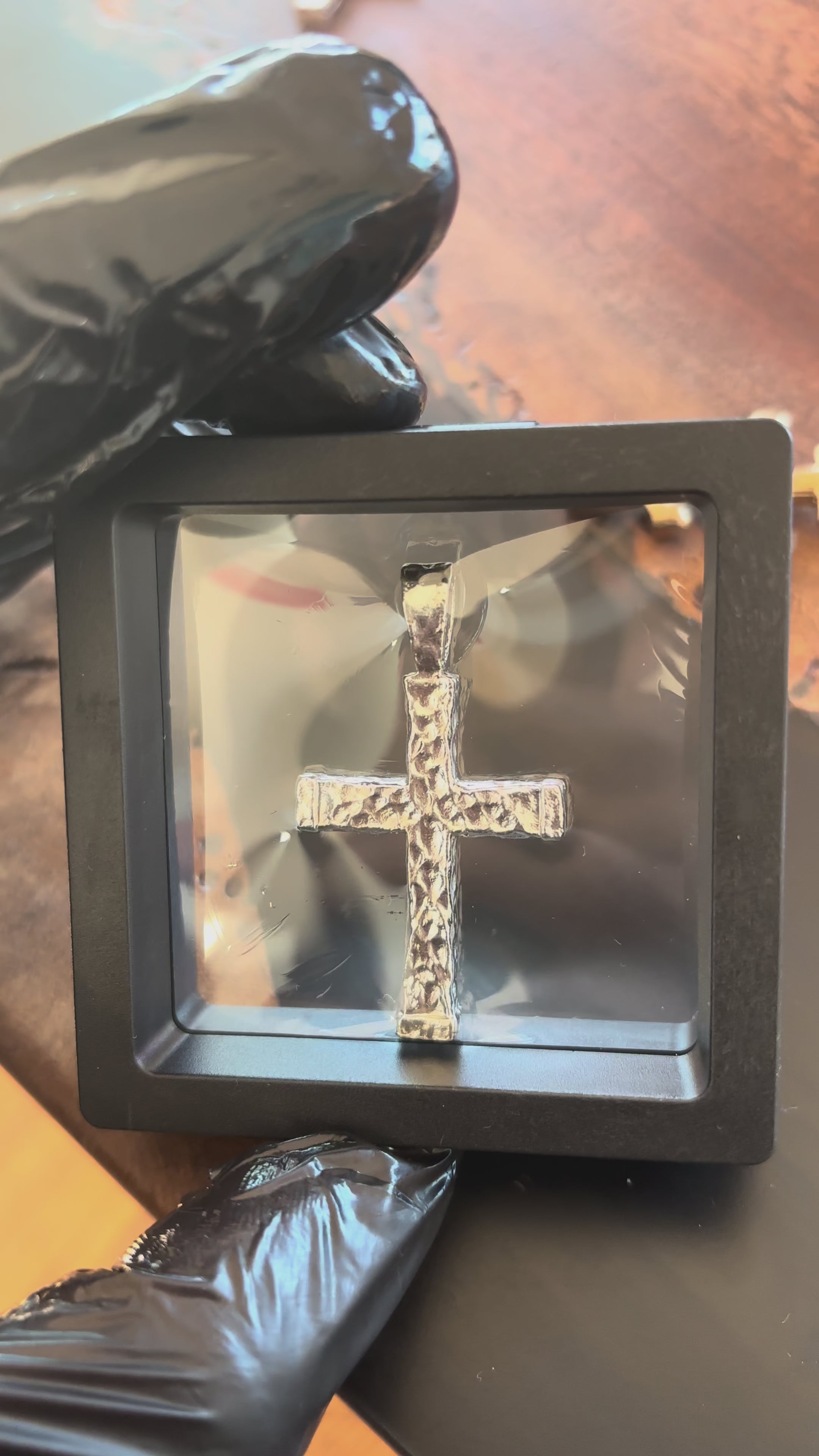 Hand-cast silver Signature Cross pendant shown in hand, real video